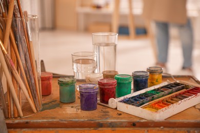 Photo of Paints and brushes in artist studio, closeup