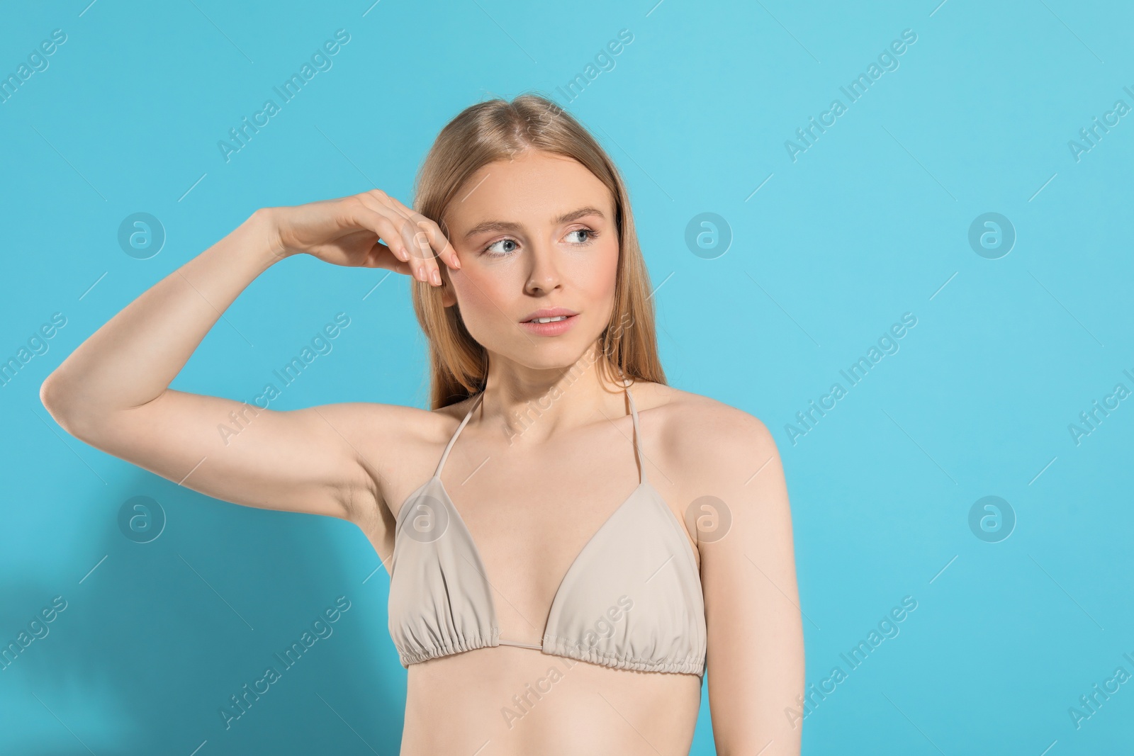 Photo of Beautiful young woman posing on light blue background