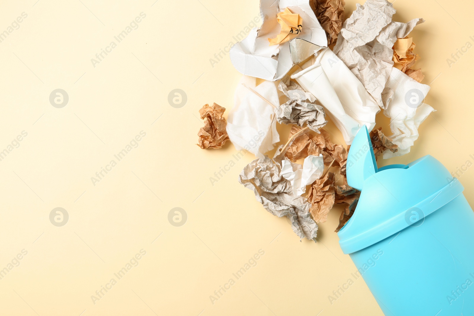 Photo of Trash bin and different garbage on color background, top view with space for text. Waste recycling concept