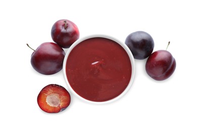 Photo of Plum puree in bowl and fresh fruits on white background, top view