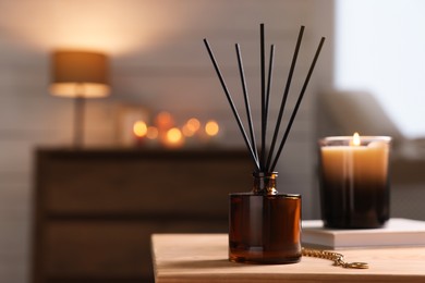 Photo of Reed diffuser on wooden table indoors. Space for text
