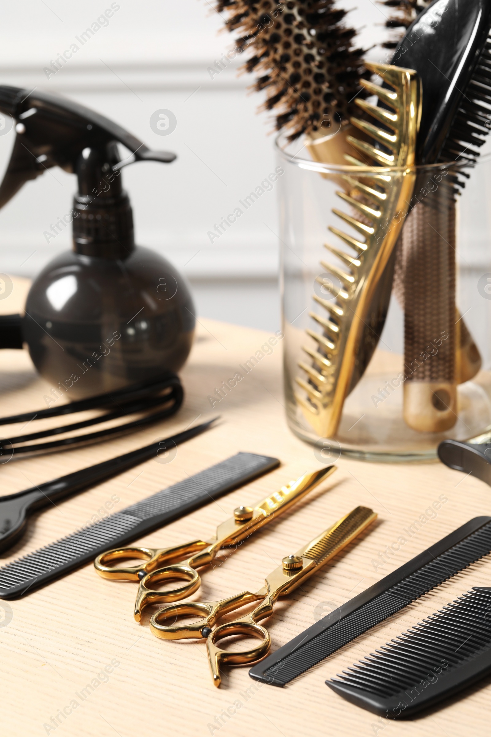 Photo of Hairdresser tools. Different scissors and combs on wooden table in salon