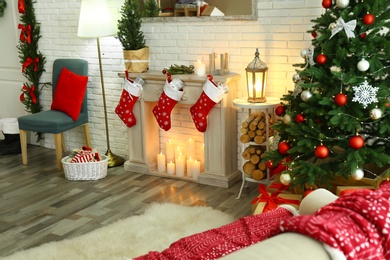 Stylish interior with beautiful Christmas tree and decorative fireplace