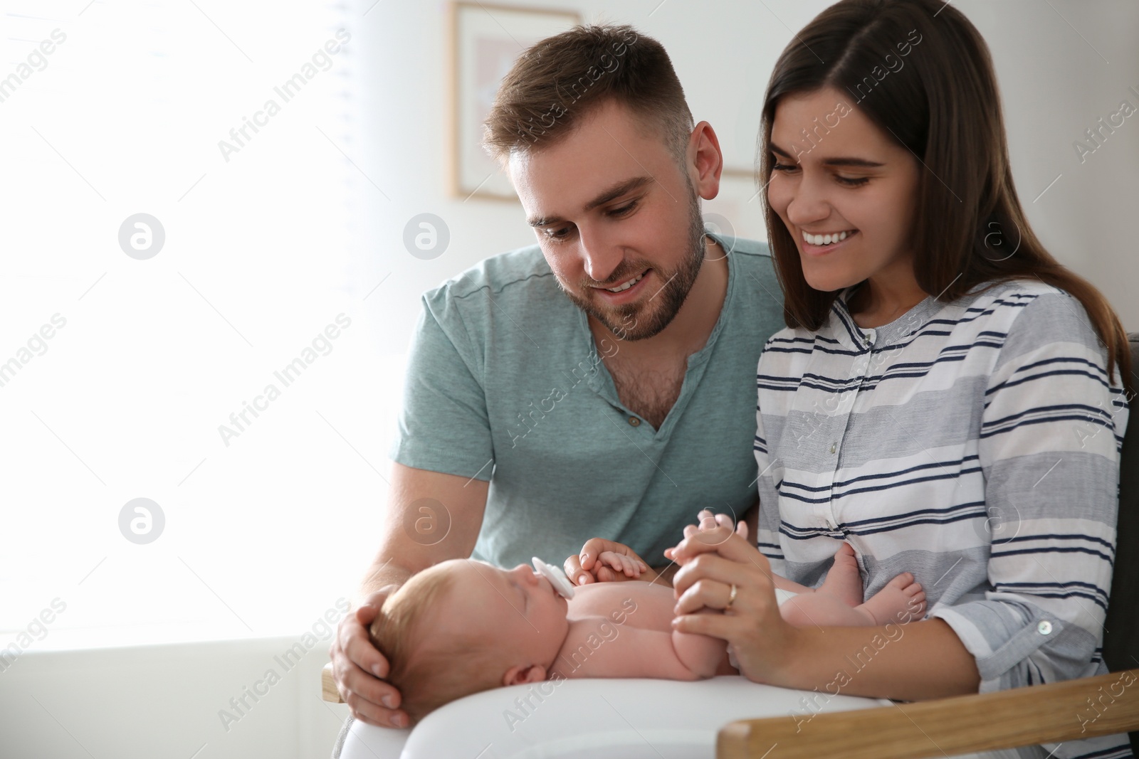 Photo of Happy couple with their newborn baby at home