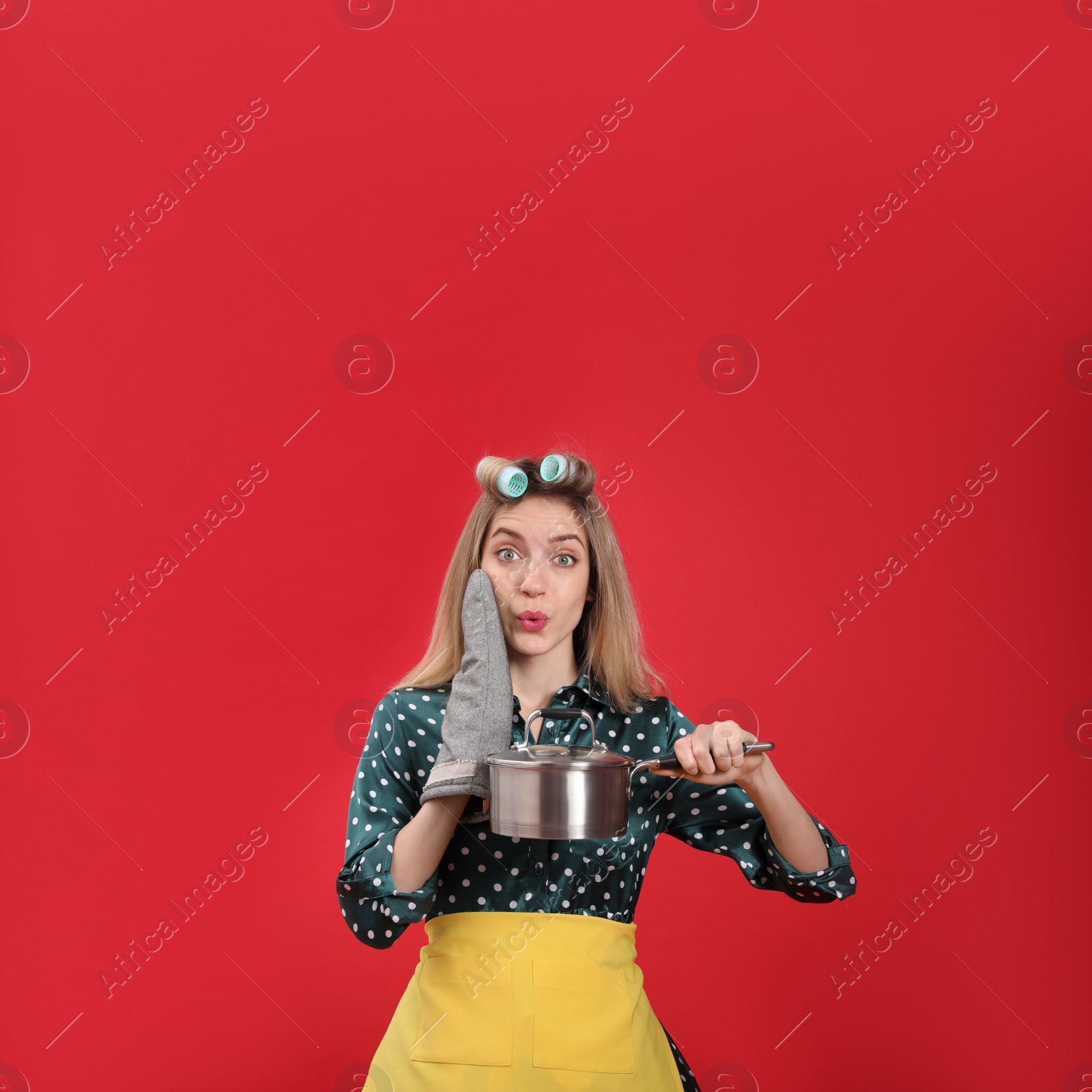 Photo of Young housewife with saucepan on red background