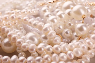 Photo of Elegant pearl necklaces as background, closeup view