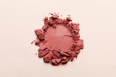Photo of Crushed eye shadow on beige background, top view