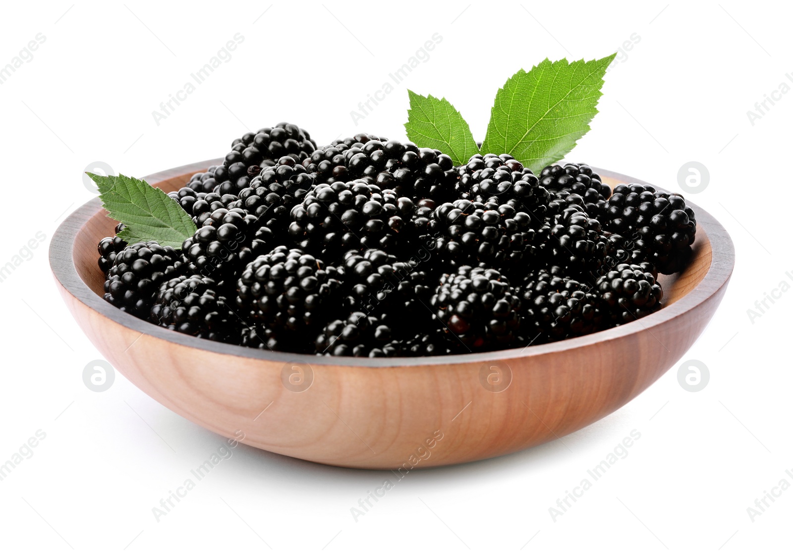 Photo of Wooden bowl of tasty ripe blackberries with leaves on white background