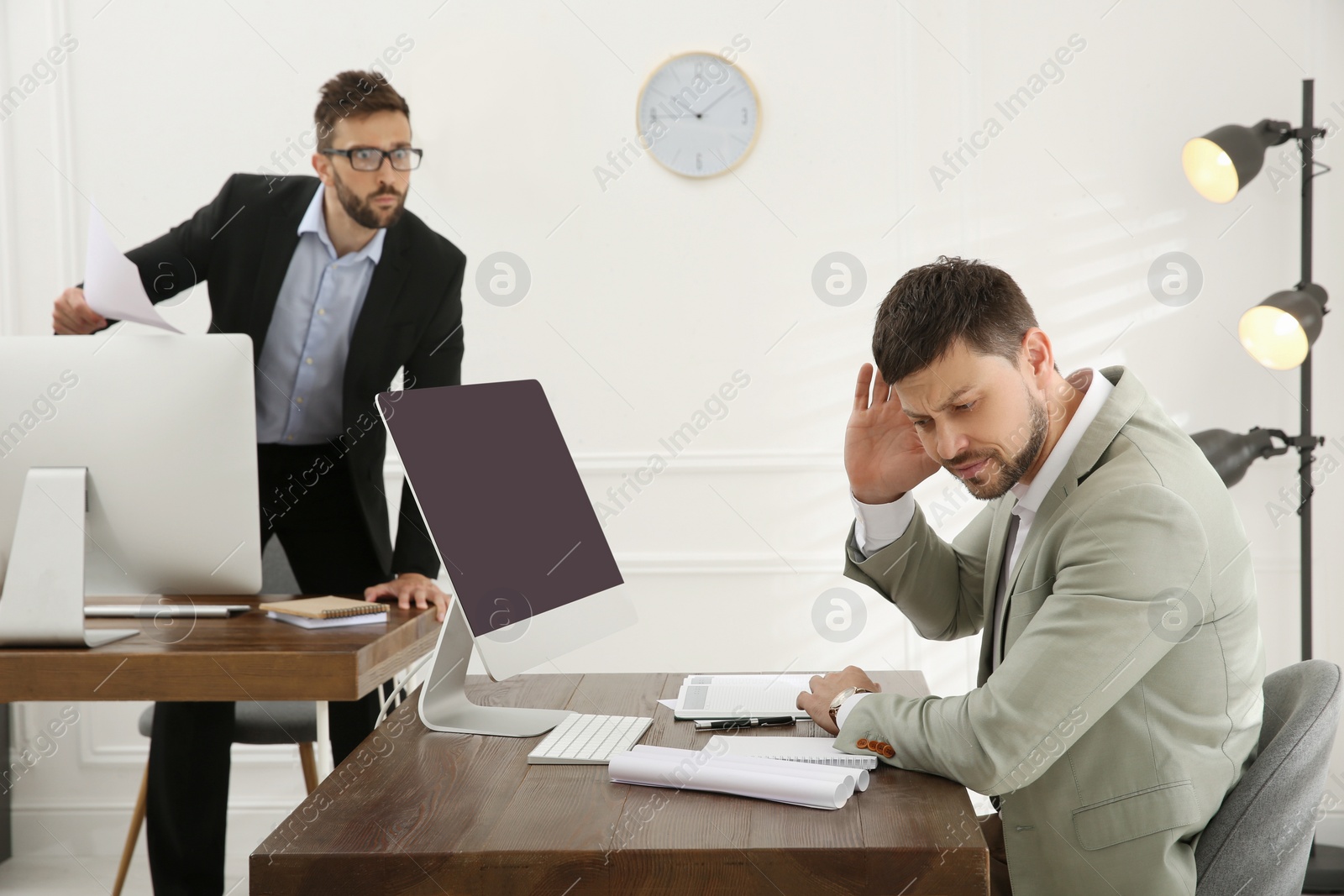 Photo of Boss scolding employee in office. Toxic work environment