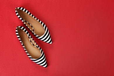 Pair of female shoes on color background, top view