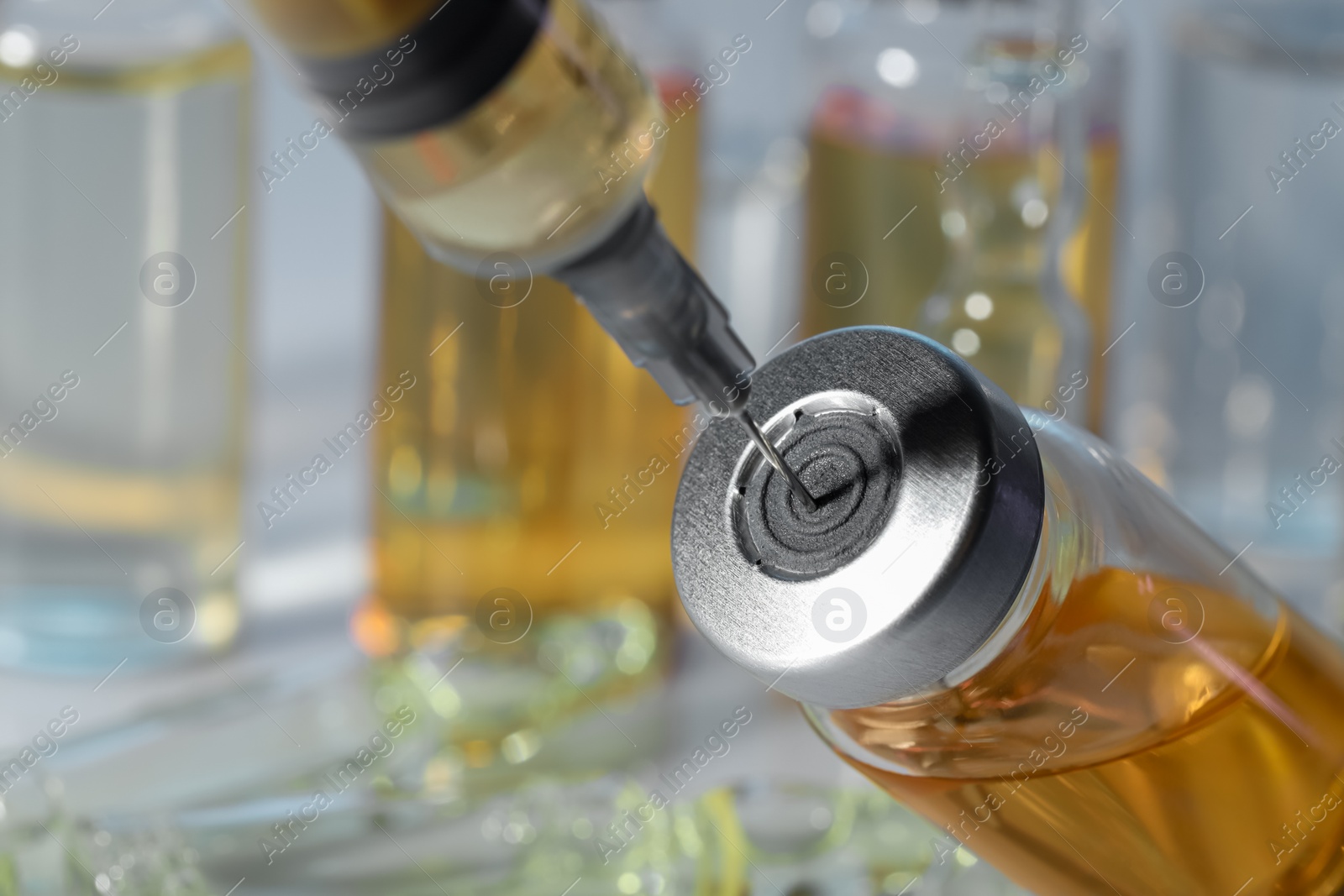 Photo of Filling syringe with orange medication from glass vial, closeup. Space for text