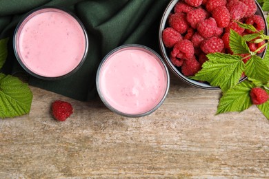 Photo of Tasty raspberry smoothie and fresh berries on wooden table, flat lay. Space for text