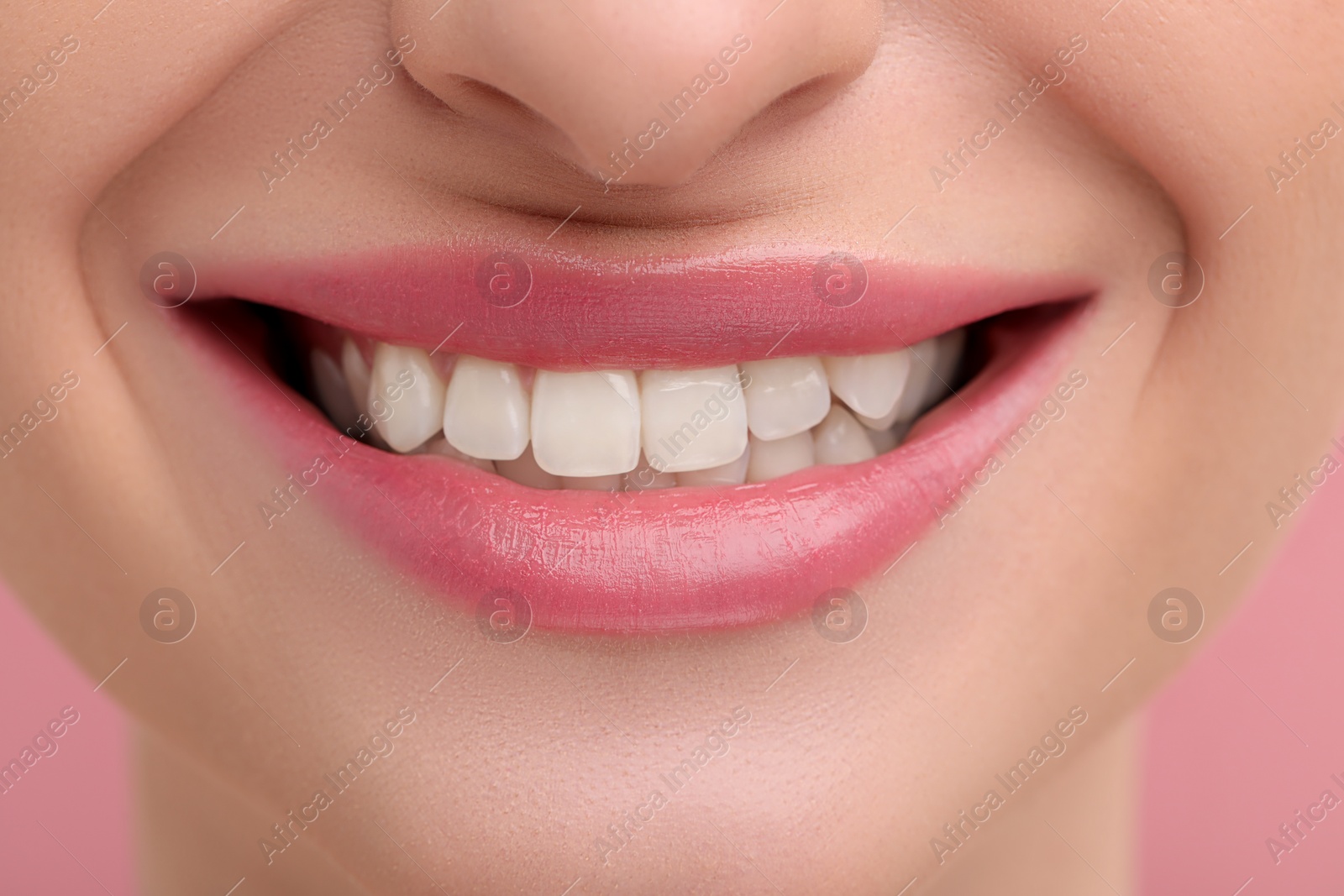 Photo of Young woman with beautiful smile on pink background, closeup