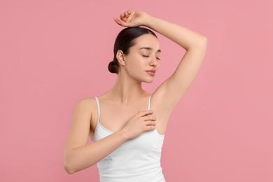 Photo of Beautiful woman showing armpit with smooth clean skin on pink background