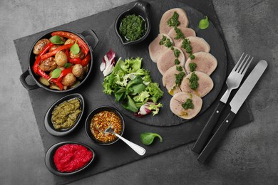 Photo of Tasty beef tongue pieces and ingredients served on grey table, top view