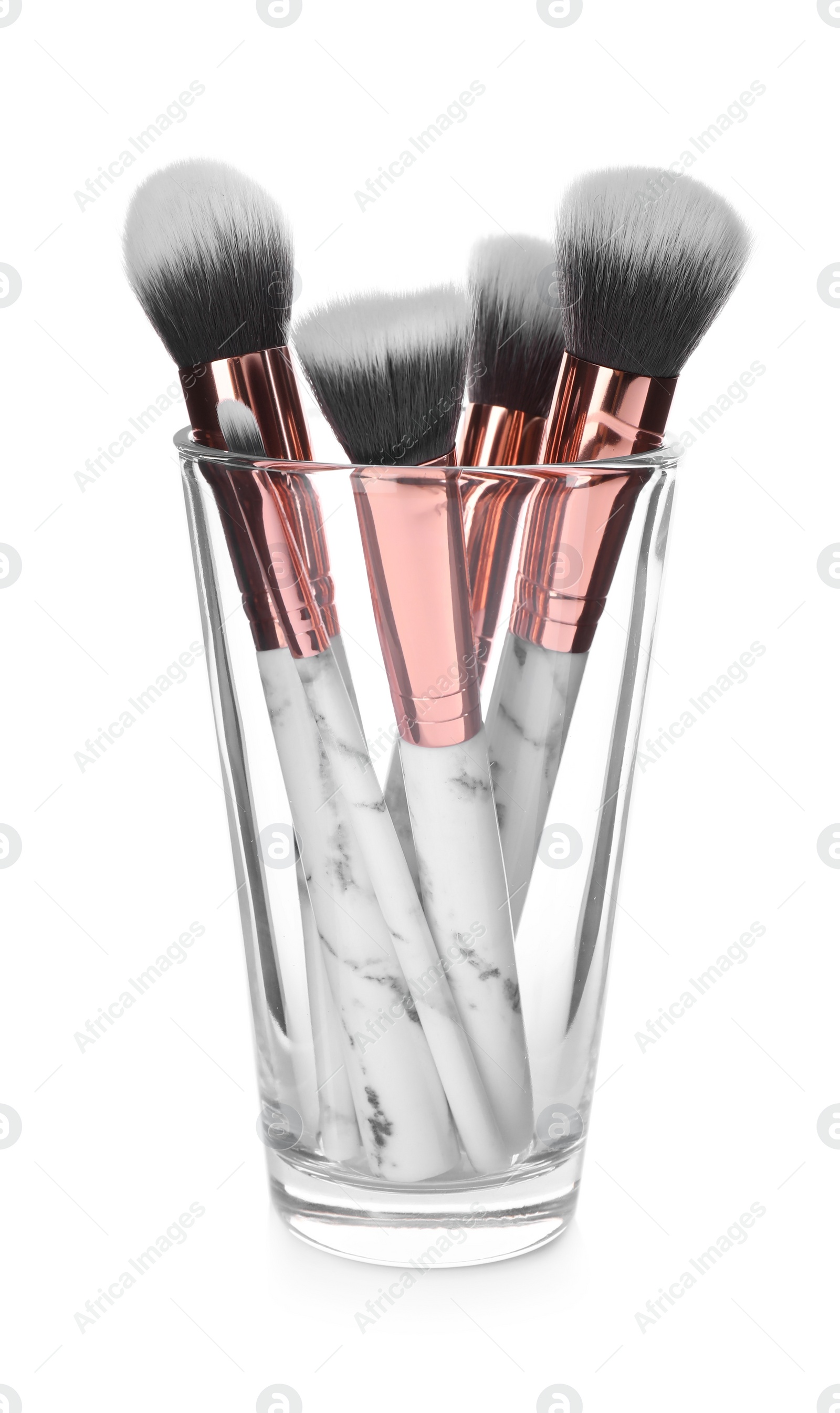 Photo of Set of professional makeup brushes in glass isolated on white