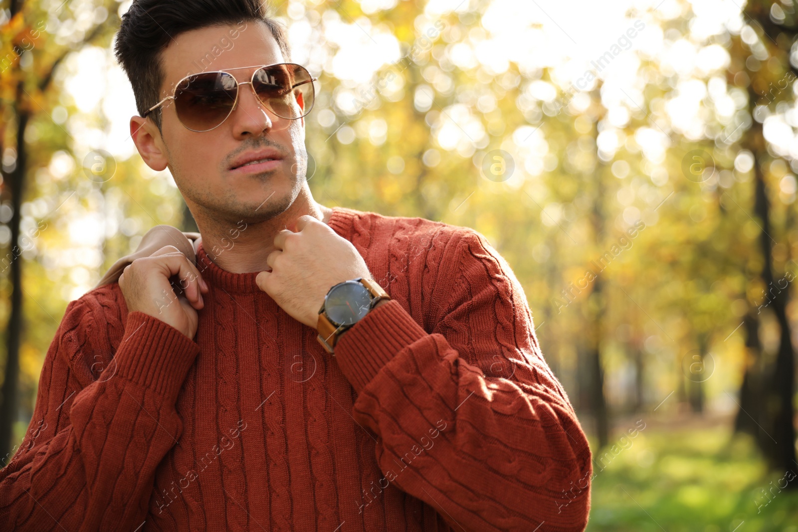 Photo of Handsome man walking in park on autumn day