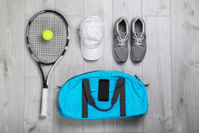 Photo of Flat lay composition with sports bag on wooden floor