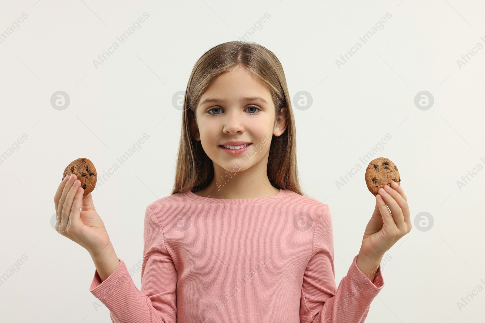 Photo of Cute girl with chocolate chip cookies on white background