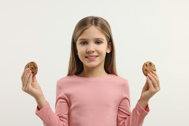 Cute girl with chocolate chip cookies on white background