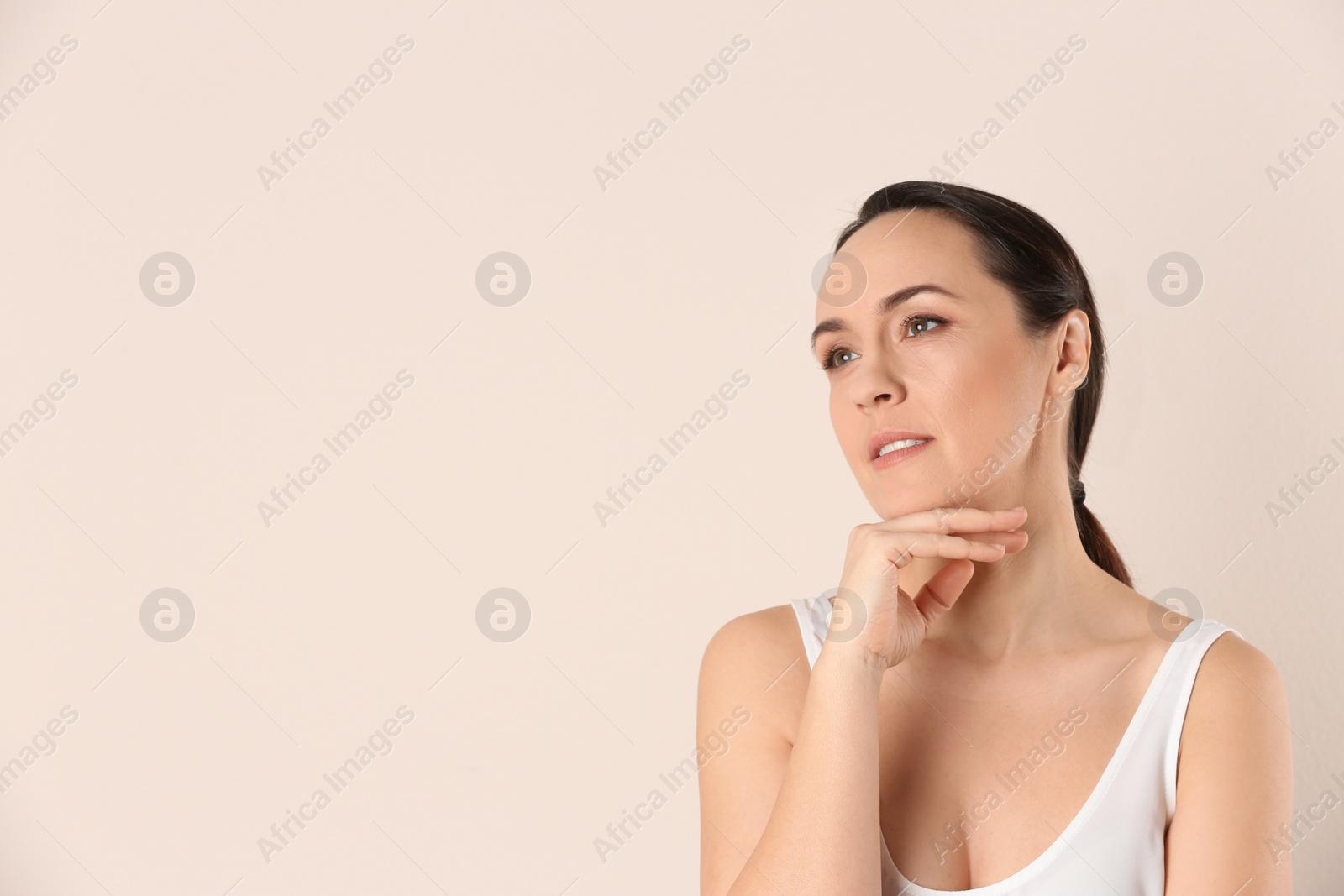 Photo of Portrait of beautiful mature woman on beige background. Space for text