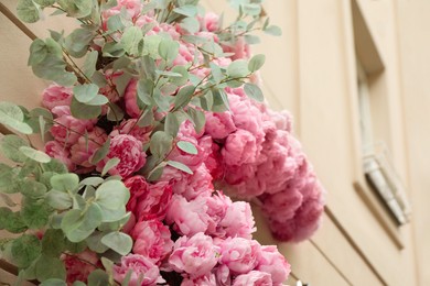 Building decorated with beautiful peony flowers, closeup