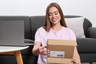 Happy woman unpacking parcel at home. Online store
