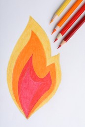 Drawing of fire and colorful pencils on white background, top view