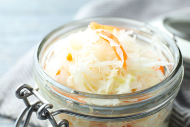 Photo of Jar with tasty homemade fermented cabbage, closeup