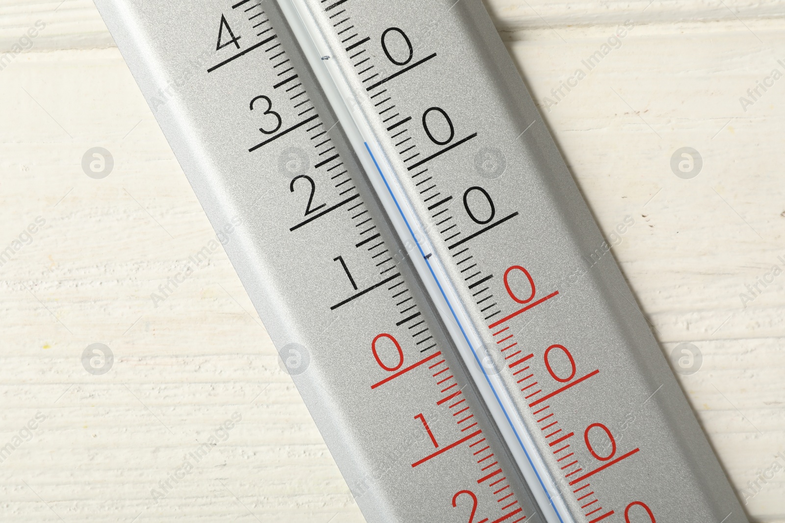 Photo of Modern weather thermometer on white wooden background, closeup