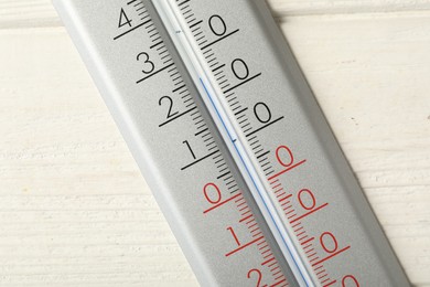 Photo of Modern weather thermometer on white wooden background, closeup