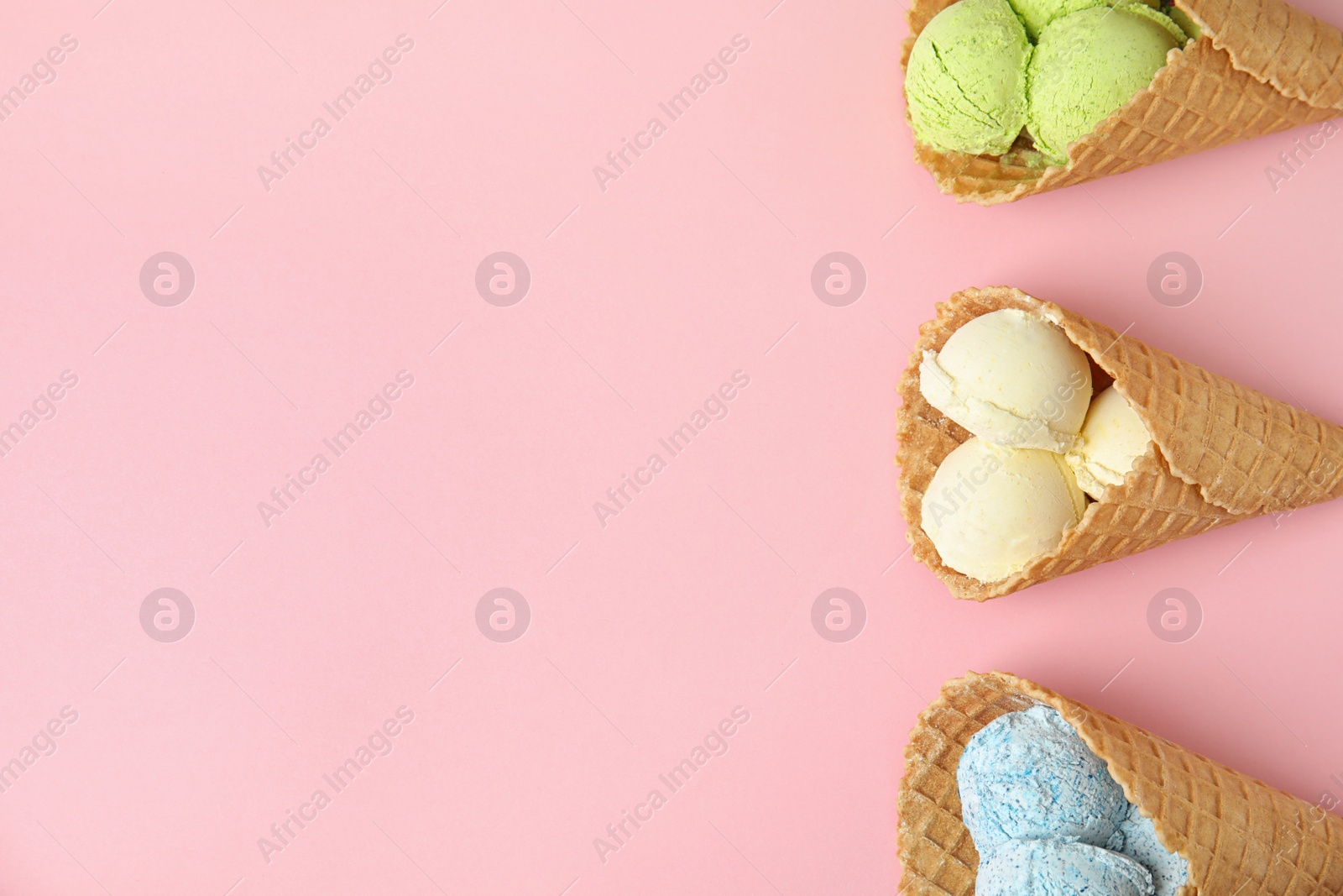 Photo of Flat lay composition with delicious ice creams in waffle cones on color background, space for text