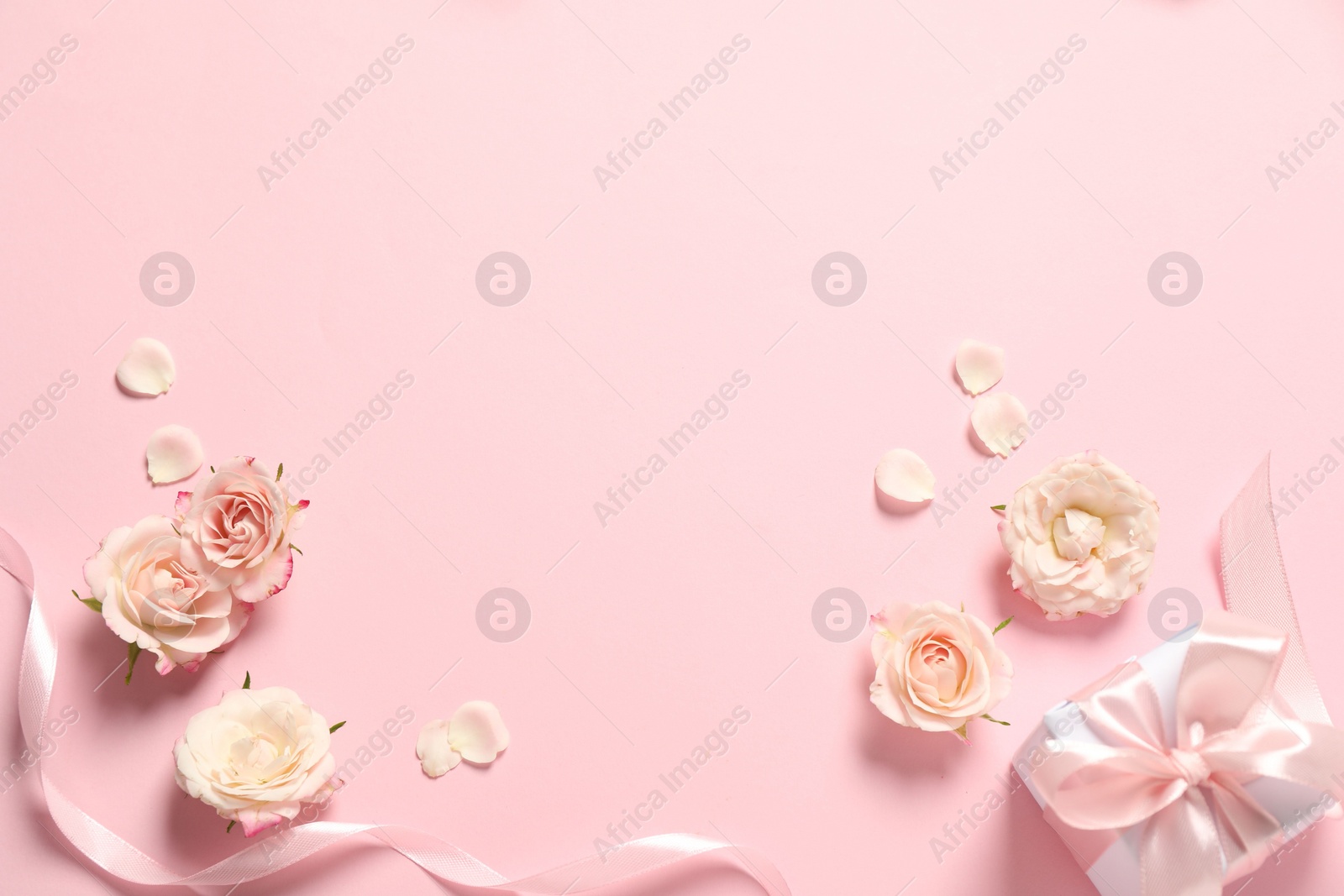 Photo of Happy Mother's Day. Beautiful flowers, gift box and ribbon on pink background, flat lay. Space for text