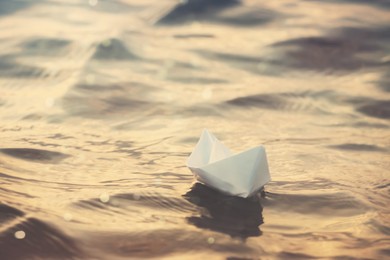 White paper boat floating on river. Retro photo effect