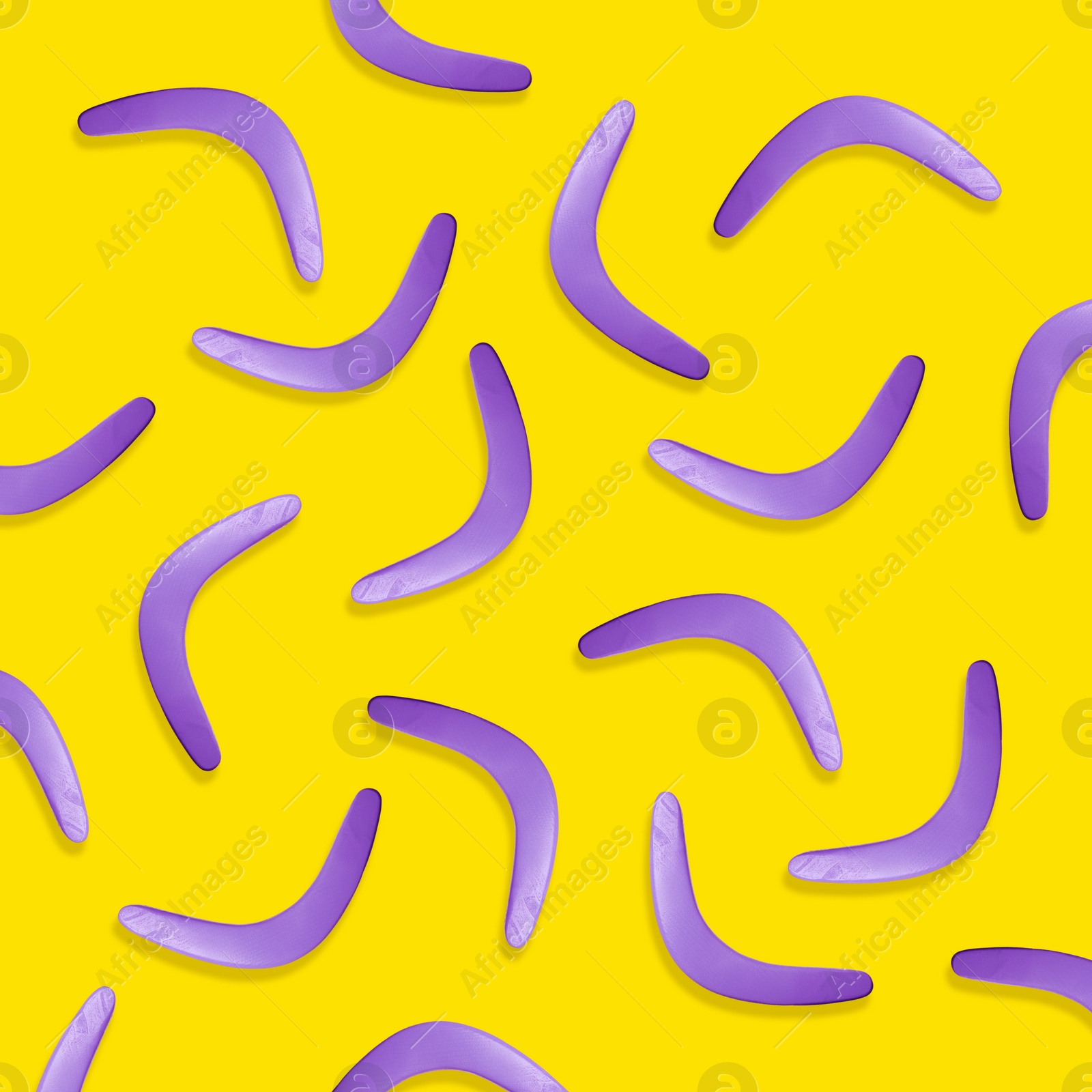 Image of Violet boomerangs on yellow background, flat lay