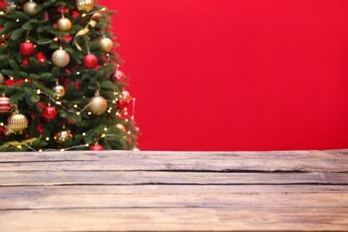 Photo of Wooden table and blurred Christmas tree with fairy lights on background