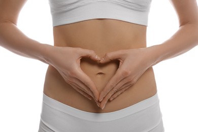 Photo of Woman making heart with her hands on belly against white background, closeup