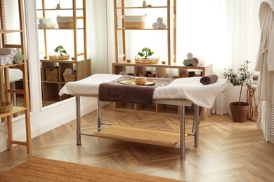 Photo of Stylish room interior with massage table in spa salon