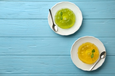 Photo of Flat lay composition with plates of fruit jelly on blue wooden table, space for text