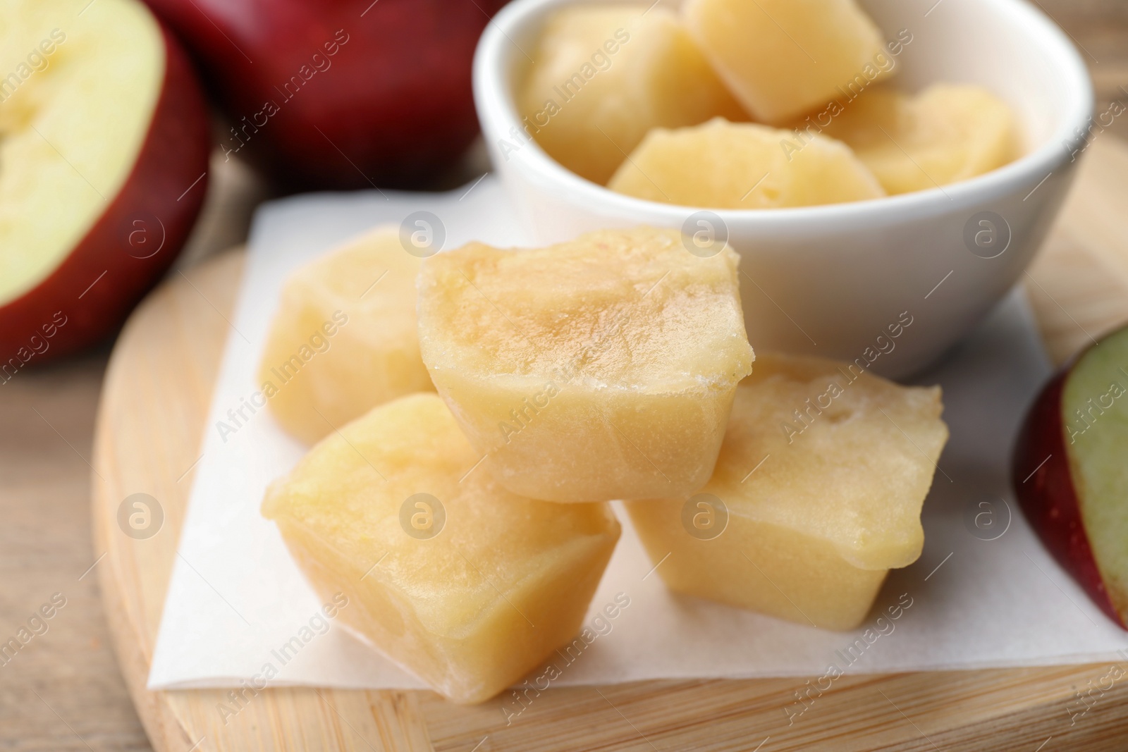 Photo of Frozen apple puree cubes and ingredient on wooden table, closeup