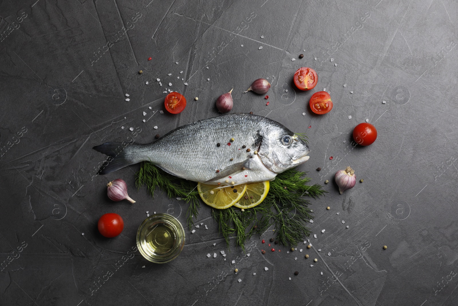 Photo of Fresh dorado fish and ingredients on grey table, flat lay