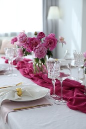 Photo of Beautiful table setting with pink peonies in dining room