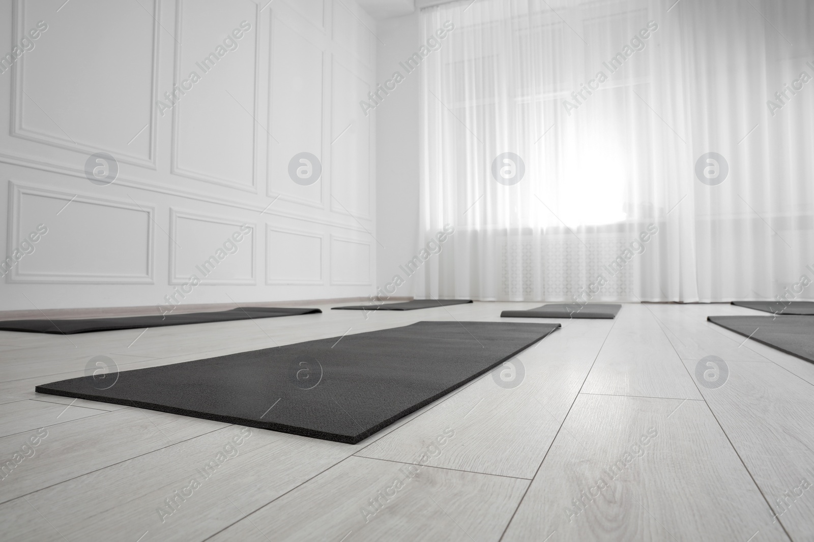 Photo of Spacious yoga studio with exercise mats. Space for text