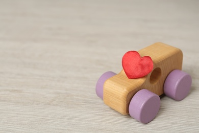 Wooden toy with and decorative heart on table, space for text. Happy Valentine's Day