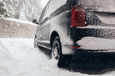 Modern car covered with snow outdoors on winter day, closeup