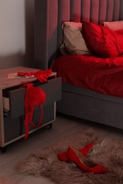 Prostitution concept. Red women`s underwear, euro banknotes and high heeled shoes indoors