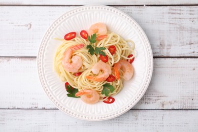 Tasty spaghetti with shrimps, chili pepper and parsley on wooden rustic table, top view