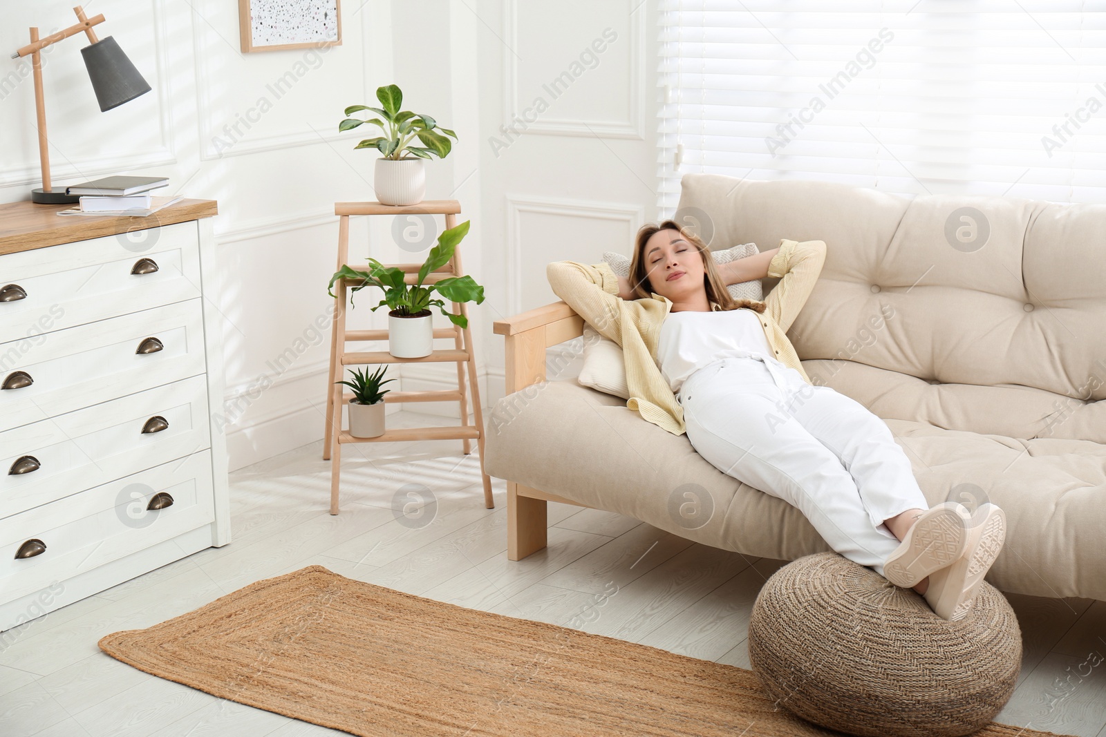 Photo of Beautiful young woman relaxing on sofa at home