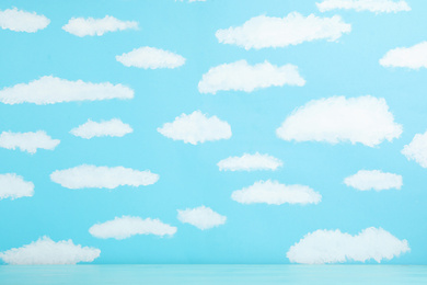 Photo of Wooden table near wall with painted blue sky. Idea for baby room interior