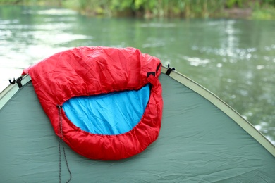 Photo of Sleeping bag on camping tent near lake